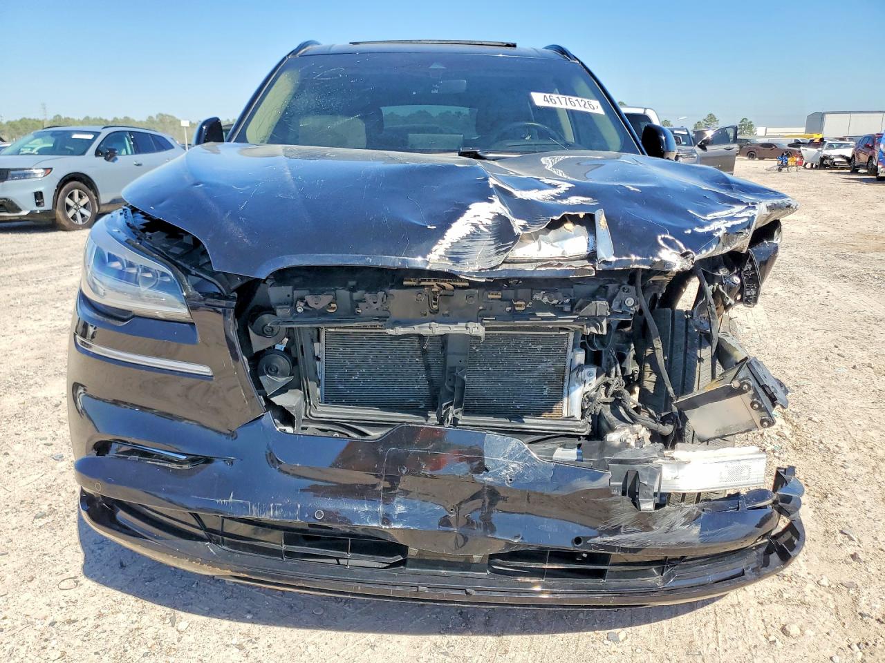 Front view showing crushed hood, missing grille and left headlight, and damaged bumper